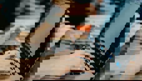 Hænder der taster på tastatur på bærbar PC